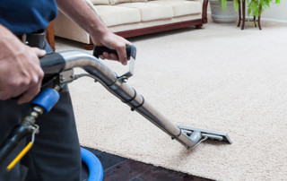 Professional steam cleaning of a beige nylon carpet in a residential home.